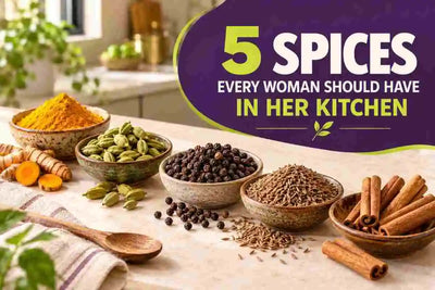 Five essential kitchen spices including turmeric, green cardamom, black pepper, cumin seeds, and cinnamon sticks arranged in bowls on a kitchen countertop.