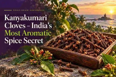 Kanyakumari cloves displayed in a wooden tray with clove buds and coastal sunset scenery, highlighting India’s aromatic single-origin spice.