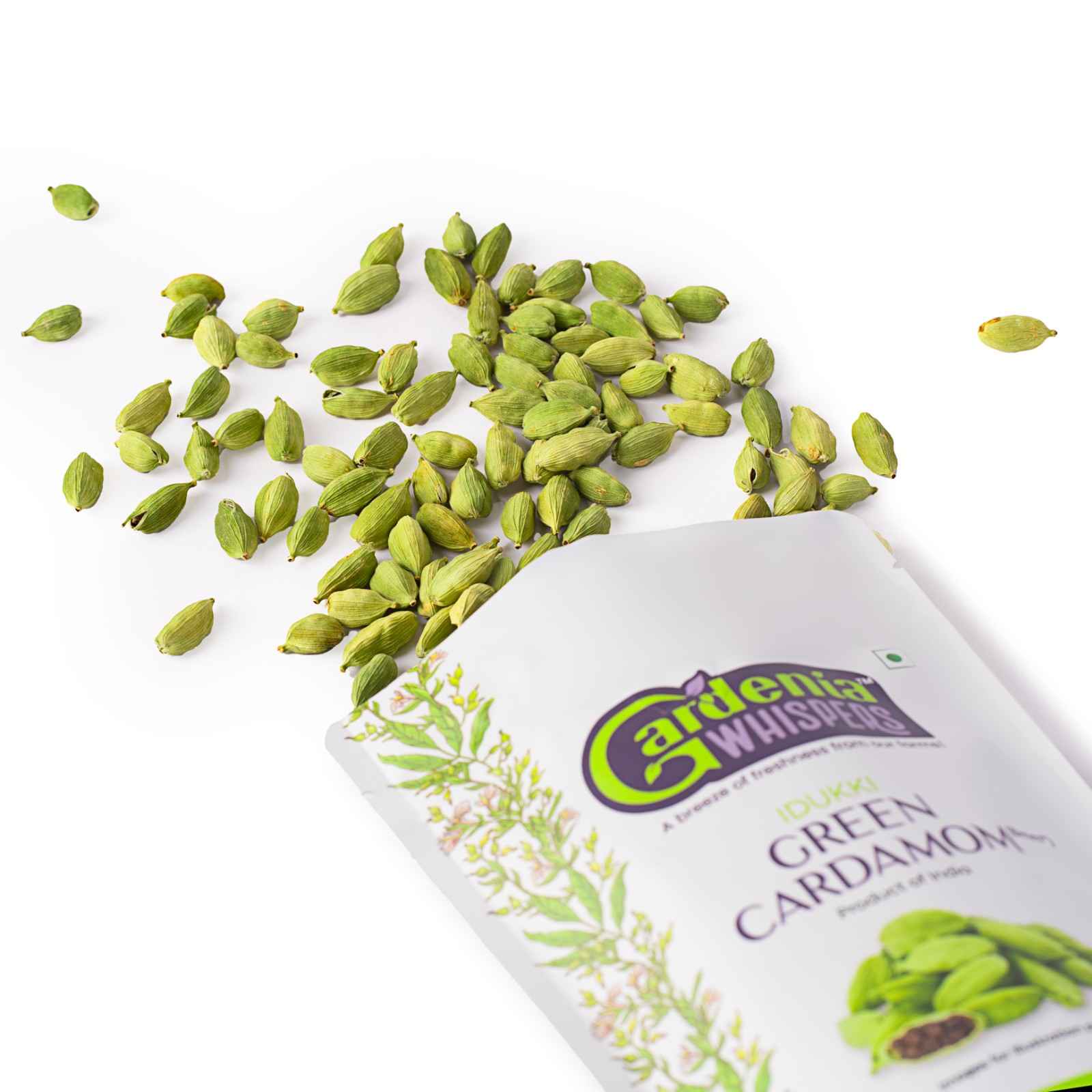 Idukki green cardamom spilling from a sealed Gardenia Whispers pack
